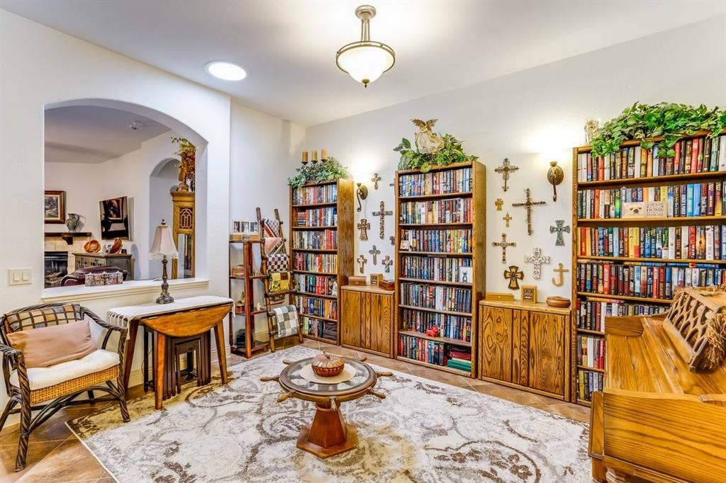 114 Lyndhurst Drive, Wylie, TX 75098 Dedicated room featuring two expansive built-in bookshelves with lower storage cabinetry, an arched entryway, recessed lighting, and a prominent ceiling light fixture