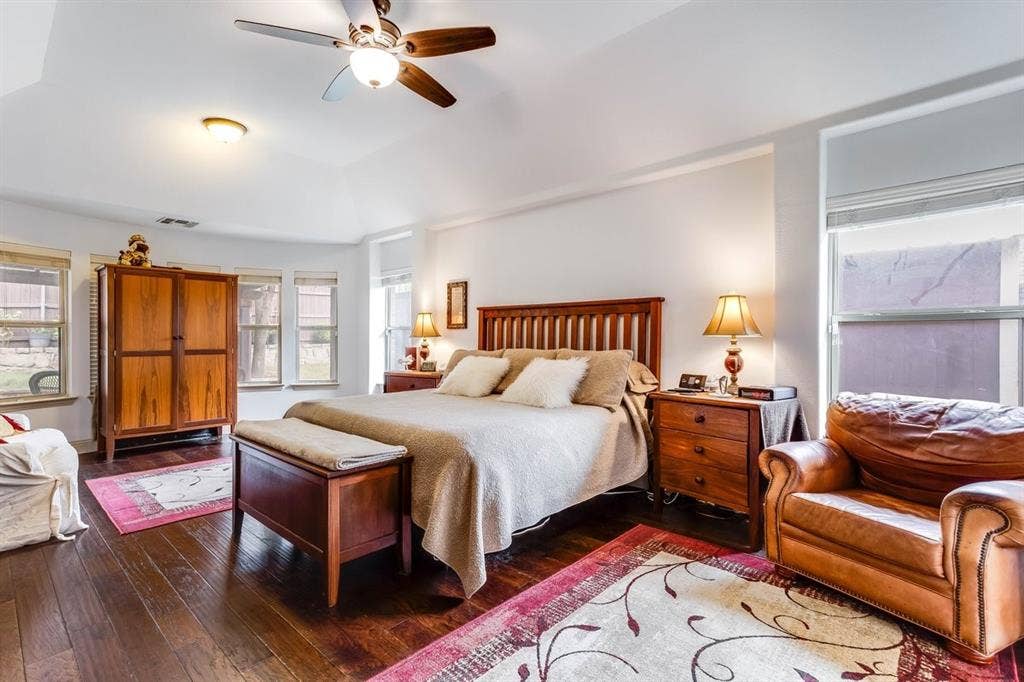 114 Lyndhurst Drive, Wylie, TX 75098 Spacious room featuring vaulted ceilings, wood-finish flooring, multiple windows, and a ceiling fan