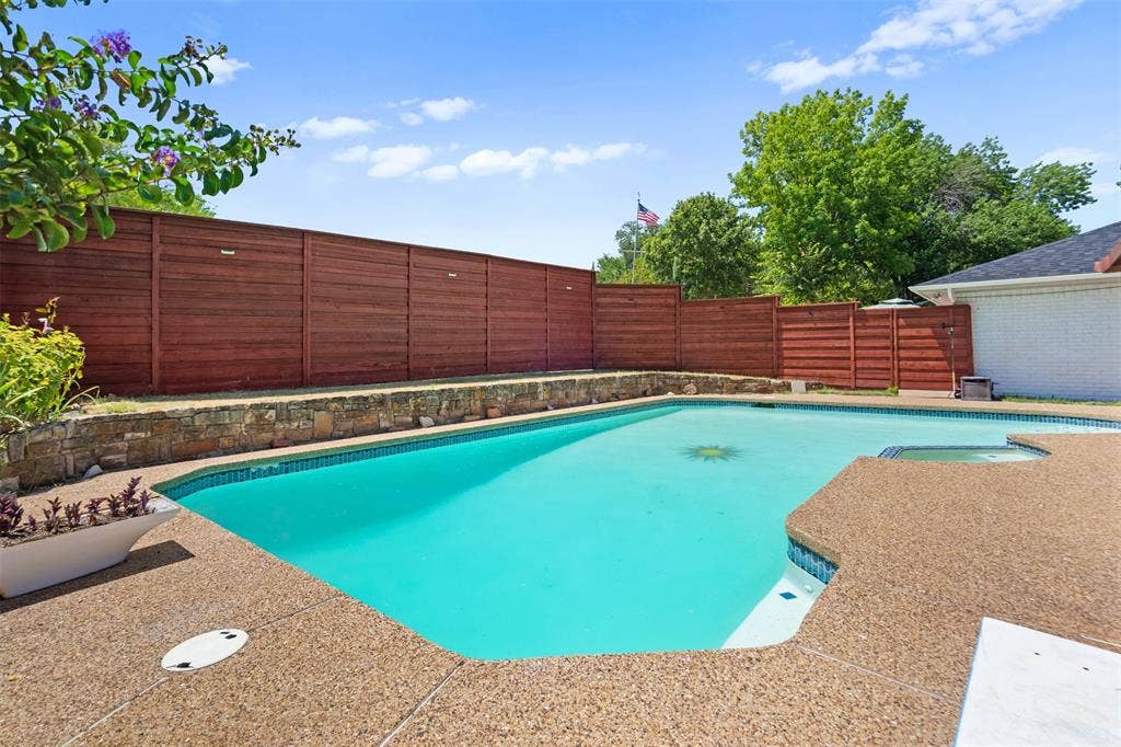 1315 Winding Brook Drive, DeSoto, TX 75115 Outdoor swimming pool with integrated spa and surrounding aggregate decking
