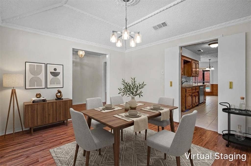 1315 Winding Brook Drive, DeSoto, TX 75115 Wood-finish flooring, recessed ceiling with decorative molding, modern chandelier, double pocket doors, and a built-in kitchen