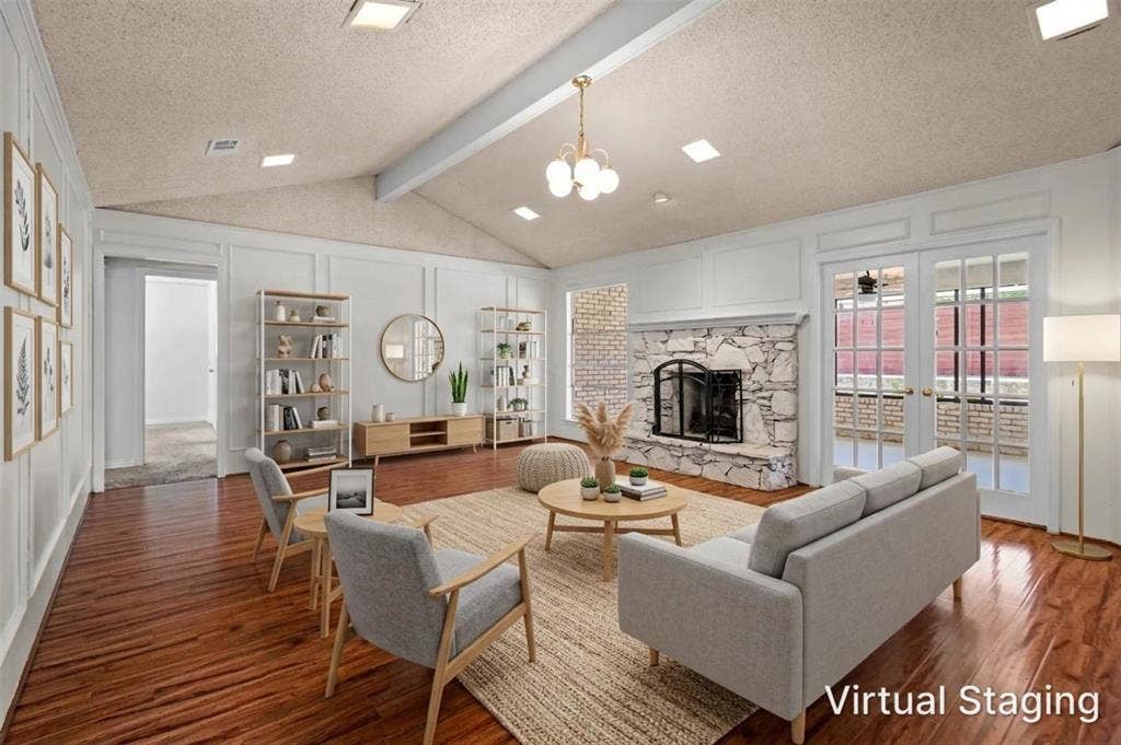 1315 Winding Brook Drive, DeSoto, TX 75115 Vaulted ceilings with exposed beam, stone-surround fireplace with hearth, wood-finish flooring, paneled wall detailing, and double French doors