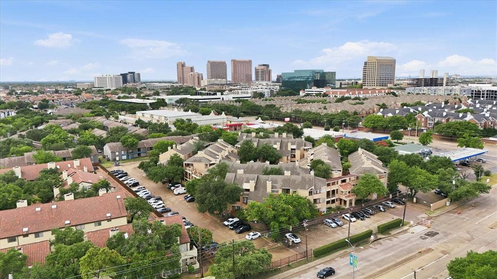 5550 Spring Valley Road, #A31, Dallas, TX 75254 Aerial perspective showcasing multiple residential buildings with terracotta-style roofs and surrounding mature trees