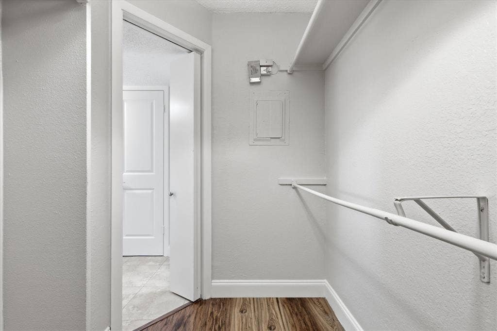 5550 Spring Valley Road, #A31, Dallas, TX 75254 Walk-in closet featuring wood-finish flooring, white walls, and a built-in hanging rod with shelving
