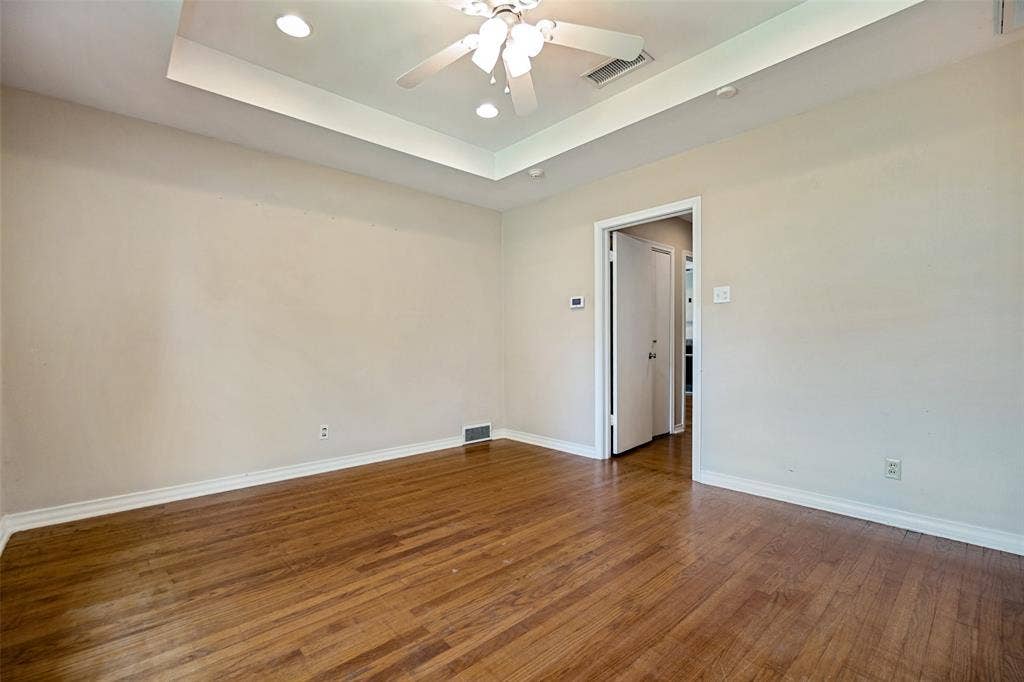 Tray ceiling in this bedroom with hardwoods