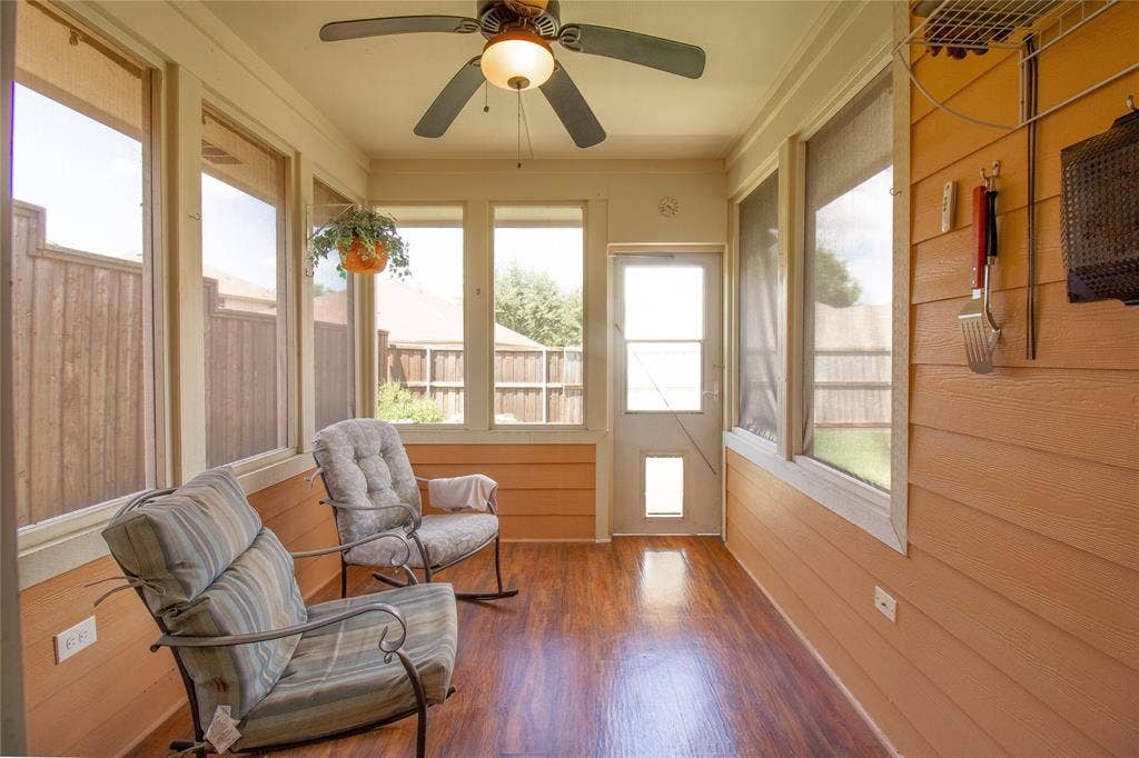 406 Hackberry Drive, Fate, TX 75087 Enclosed patio featuring wood-finish flooring, a ceiling fan with integrated lighting, numerous windows, and a screen door with a pet access panel