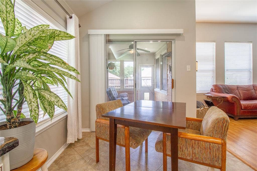 406 Hackberry Drive, Fate, TX 75087 Tiled flooring in a dining area featuring a sliding glass door leading to a screened porch