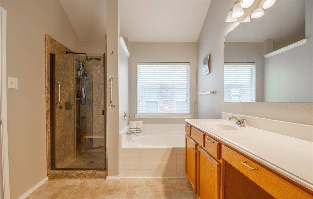406 Hackberry Drive, Fate, TX 75087 Spacious bathroom featuring a dual-sink vanity with light wood cabinetry and a large mirror