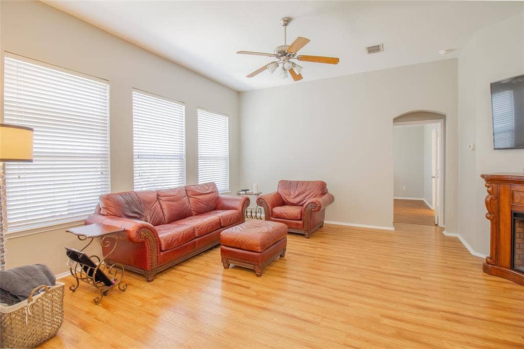 406 Hackberry Drive, Fate, TX 75087 Living area featuring wood-finish flooring, vaulted ceiling, and an arched doorway