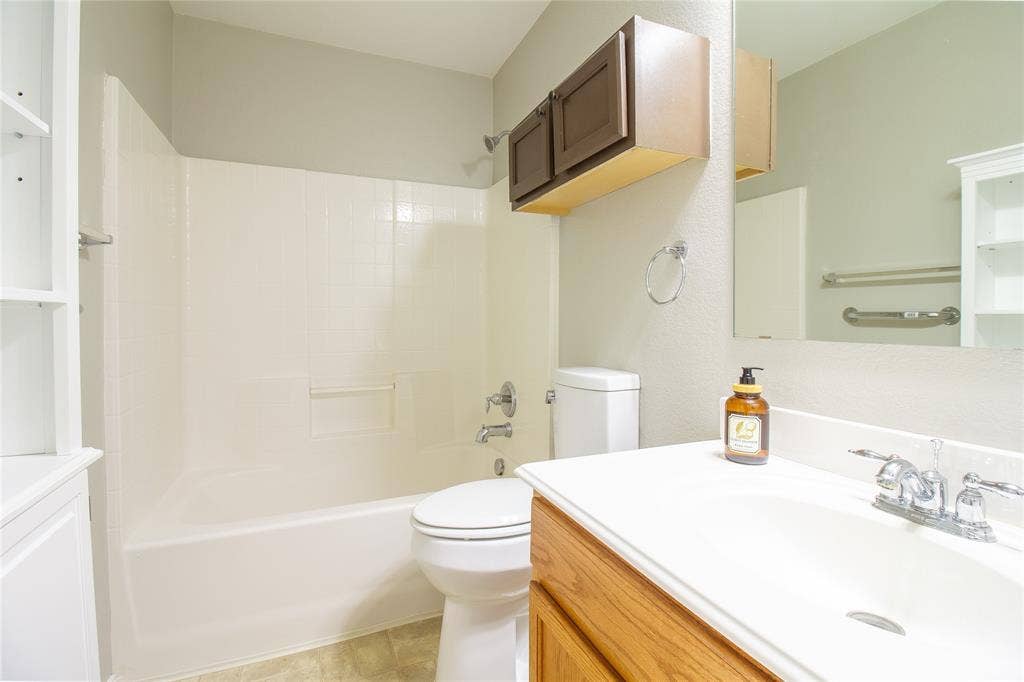 406 Hackberry Drive, Fate, TX 75087 Bathroom featuring a white bathtub, toilet, and vanity with an integrated sink