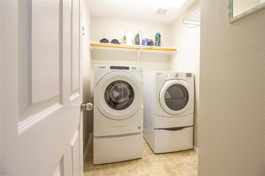 406 Hackberry Drive, Fate, TX 75087 Dedicated laundry area featuring front-loading washer and dryer units