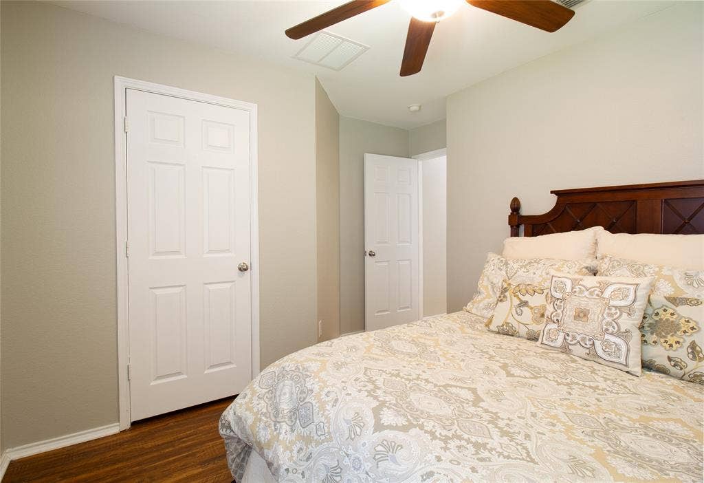 406 Hackberry Drive, Fate, TX 75087 Wood-finish flooring with white baseboards, a ceiling fan with light fixture, and panel doors