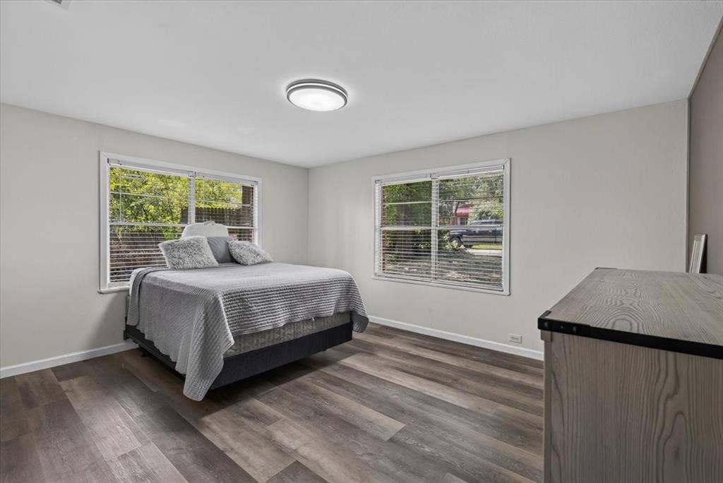 925 Maryland Drive, Athens, TX 75751 Room featuring wood-finish flooring, two large windows with blinds, light gray walls, white baseboards, and a flush-mount ceiling light fixture