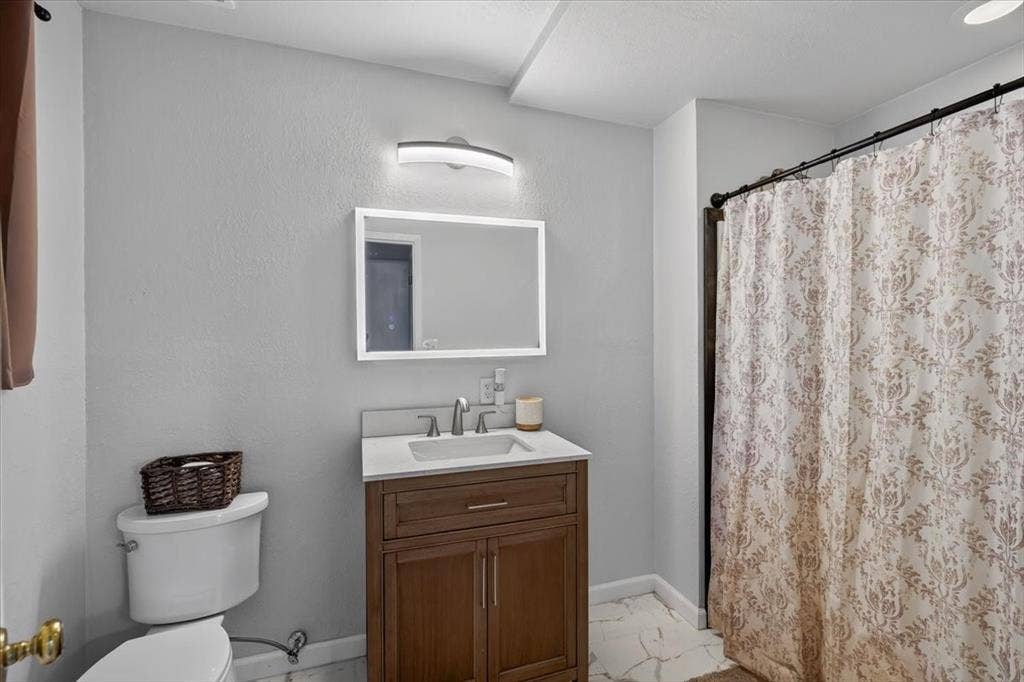 925 Maryland Drive, Athens, TX 75751 Bathroom featuring a wood-finish vanity with a white countertop and rectangular sink