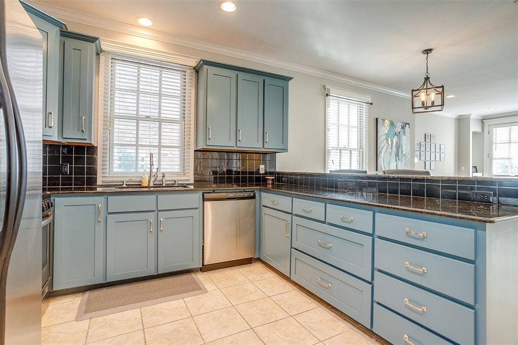 1211 S Adams Street, Fort Worth, TX 76104 Kitchen featuring light blue cabinetry with brushed nickel hardware, black tile backsplash, and dark speckled countertops