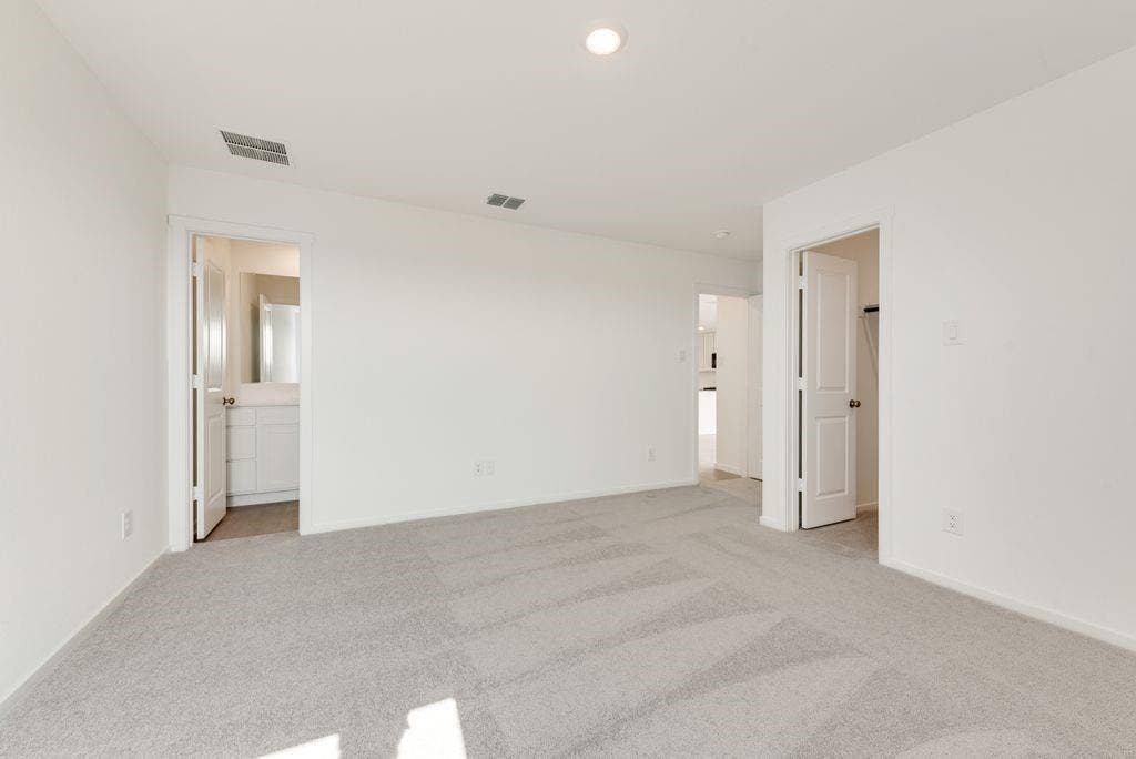 1271 Falcon Heights, Forney, TX 75126 Unfurnished bedroom featuring light carpet and connected bathroom