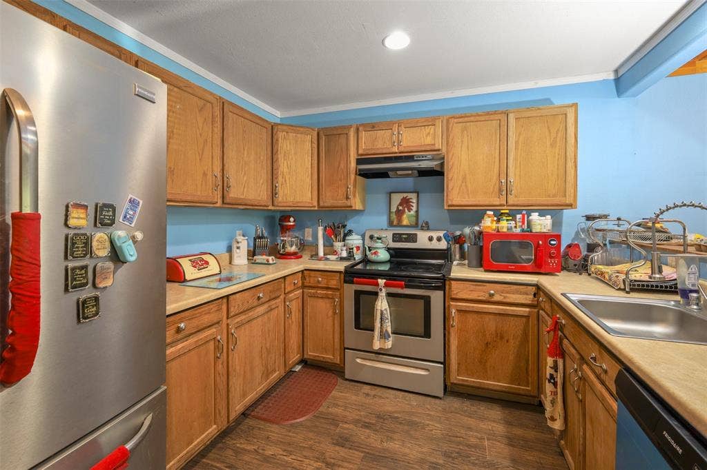 28300 County Road 2100, Kemp, TX 75143 Wood-finish flooring complementing light wood cabinetry, stainless steel appliances, and a built-in kitchen sink