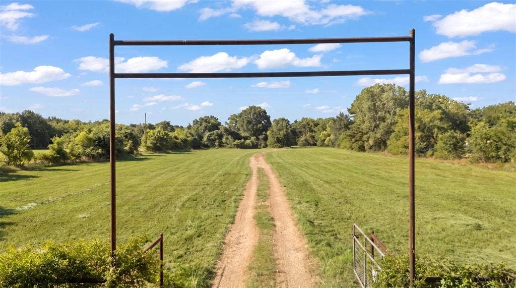 28300 County Road 2100, Kemp, TX 75143 Expansive rural property featuring a prominent metal entry arch and a dirt drive