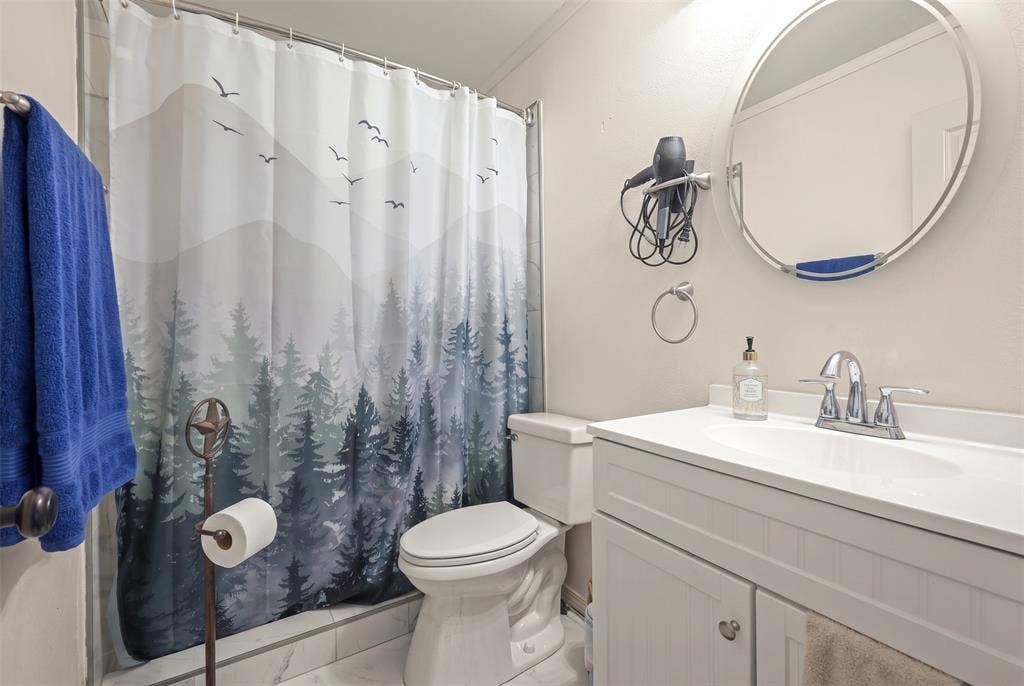 28300 County Road 2100, Kemp, TX 75143 Bathroom featuring a white vanity with integrated sink, chrome faucet, and a round mirror