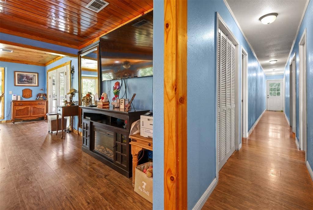 28300 County Road 2100, Kemp, TX 75143 Interior space featuring wood-finish flooring, a wood-paneled ceiling, and light blue walls