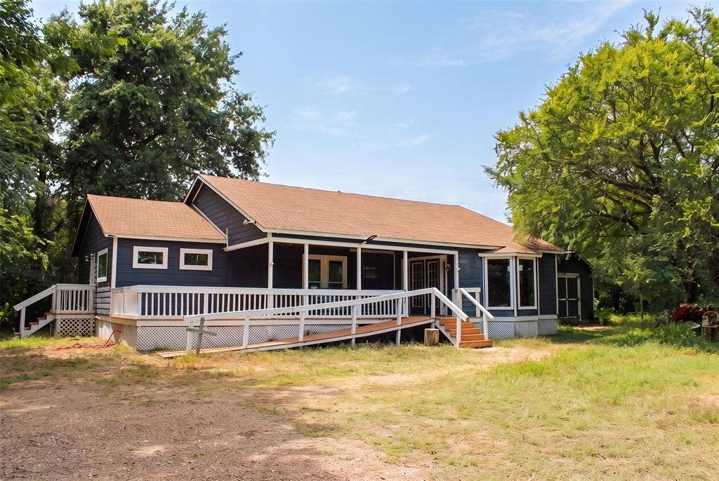 28300 County Road 2100, Kemp, TX 75143 Blue-sided single-story residence featuring a brown shingle roof, white trim, and a full-length covered porch