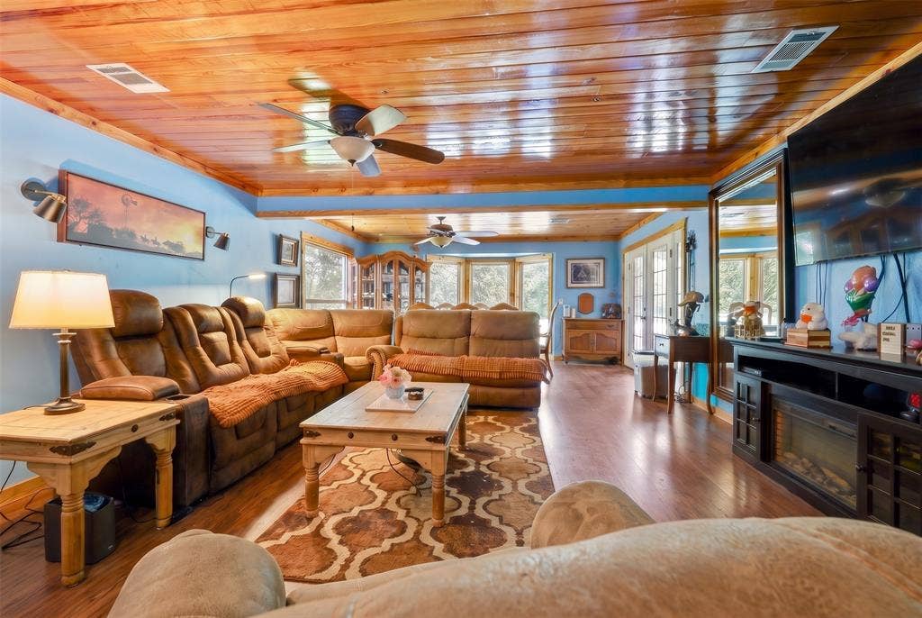 28300 County Road 2100, Kemp, TX 75143 Spacious living area featuring wood-finish flooring, a wood-paneled ceiling, and light blue walls