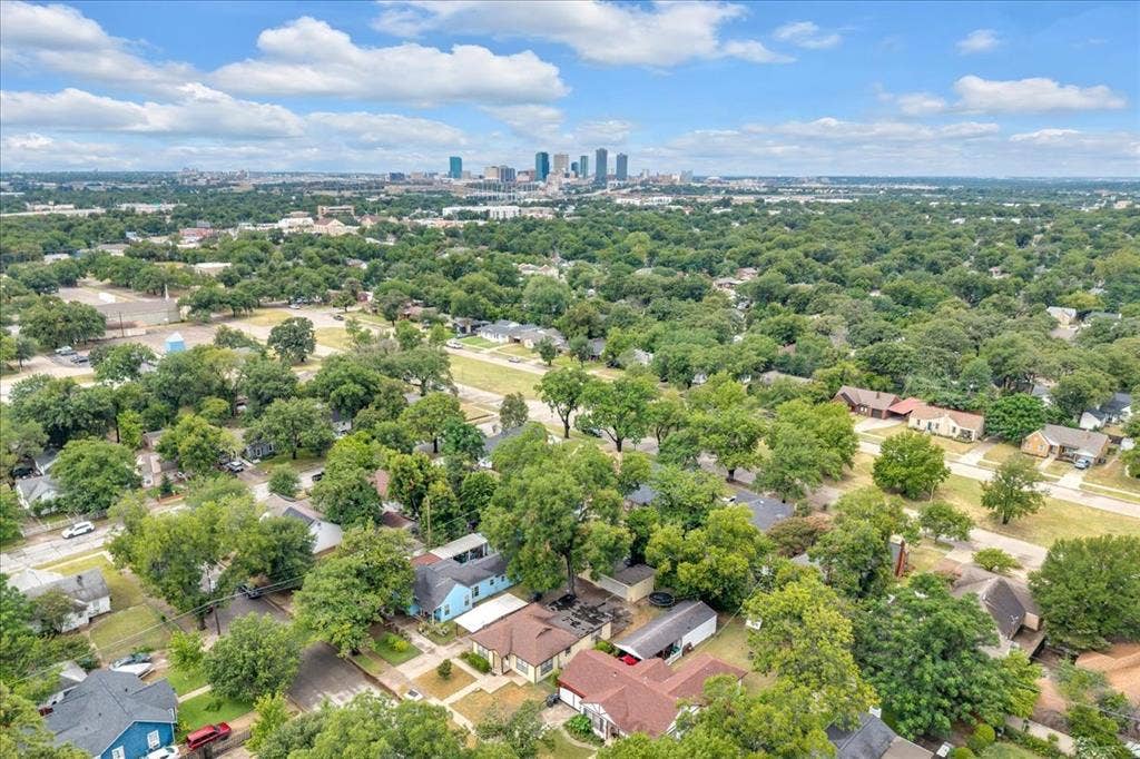1113 Hudgins Avenue, Fort Worth, TX 76111 Aerial perspective showcasing a residential area with extensive mature tree canopy