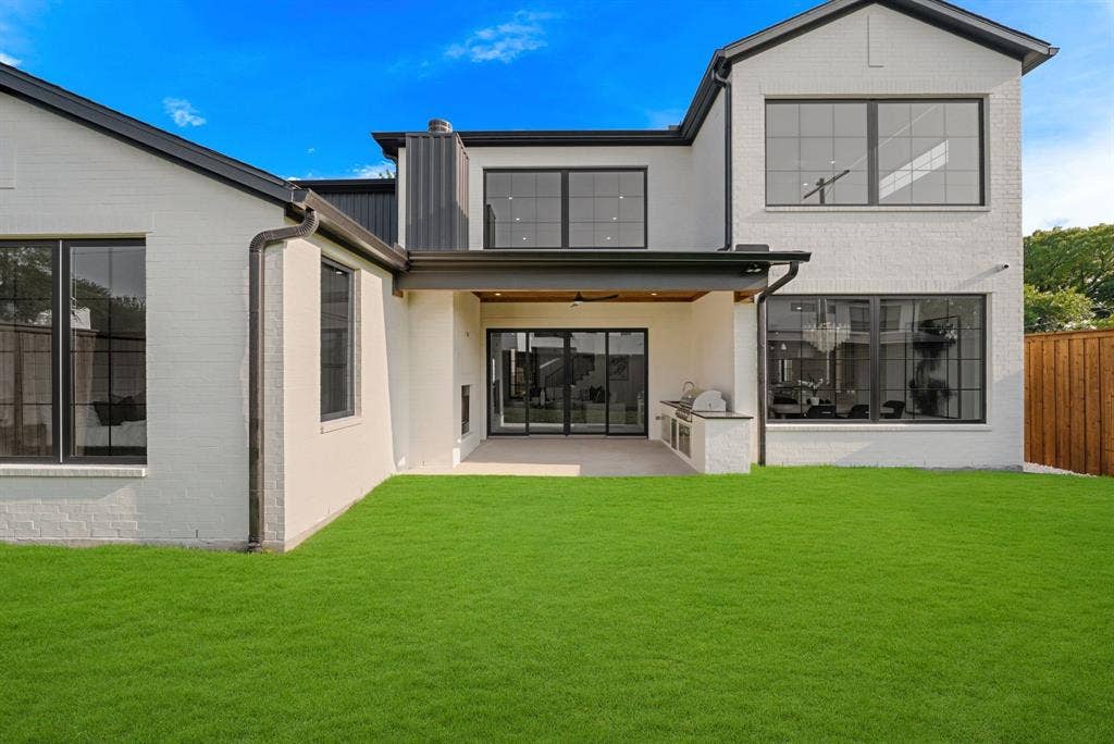 3723 Manana Drive, Dallas, TX 75220 Modern two-story residence featuring a spacious rear facade with extensive glazing, including a large multi-pane window wall and upper-level gable window
