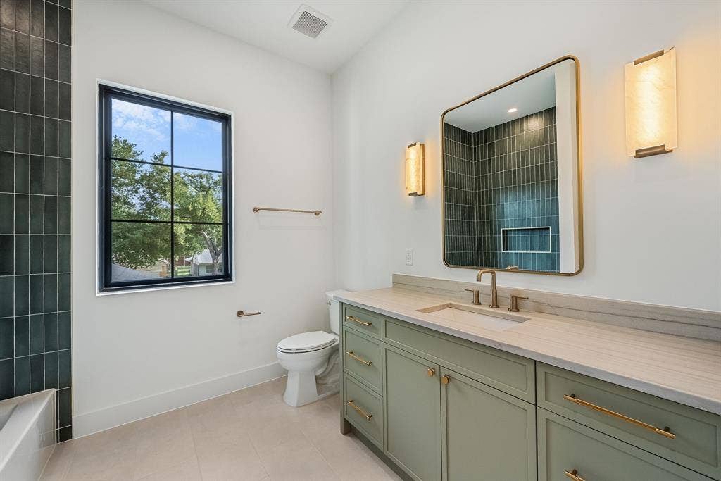 3723 Manana Drive, Dallas, TX 75220 Bathroom featuring a sage green vanity with gold-tone hardware, a rectangular undermount sink, and a light-toned stone countertop