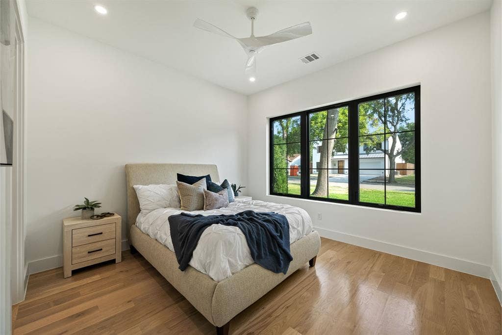 3723 Manana Drive, Dallas, TX 75220 Bedroom featuring wood-finish flooring, a contemporary ceiling fan, recessed lighting, and a large window with black gridded frames