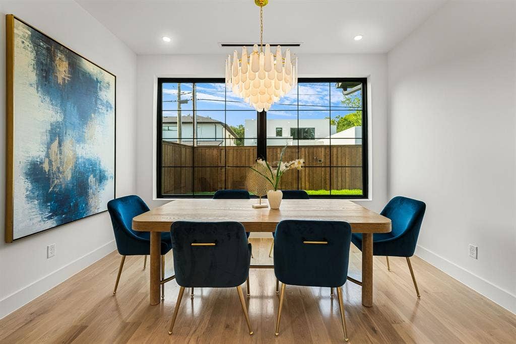 3723 Manana Drive, Dallas, TX 75220 Dining area featuring wood-finish flooring, a contemporary chandelier, and a large black-framed window