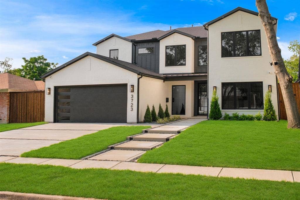 3723 Manana Drive, Dallas, TX 75220 Contemporary two-story residence featuring a white facade with black trim accents and a black garage door with frosted glass panels