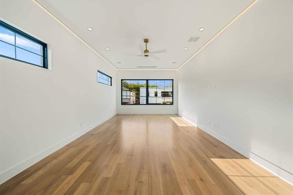 3723 Manana Drive, Dallas, TX 75220 Spacious room featuring wood-finish flooring and multiple windows with dark framing