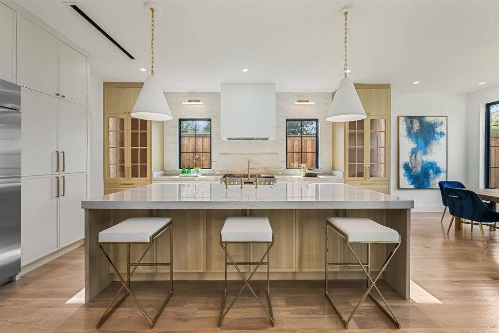 3723 Manana Drive, Dallas, TX 75220 Gourmet kitchen featuring a substantial island with seating, a professional-grade range with a built-in ventilation hood, wood-finish flooring, full-height cabinetry, and architectural pendant lighting