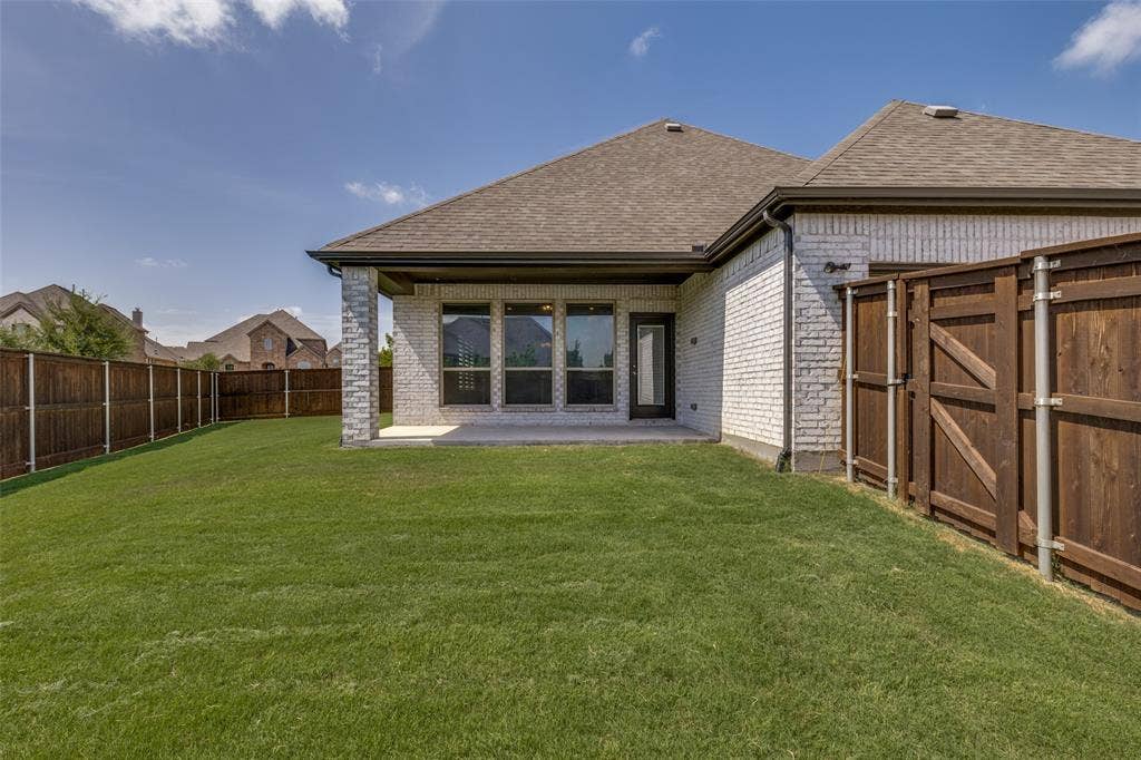 12464 Lost Valley Drive, Frisco, TX 75035 Expansive backyard featuring a manicured lawn, a full privacy fence, and a concrete patio