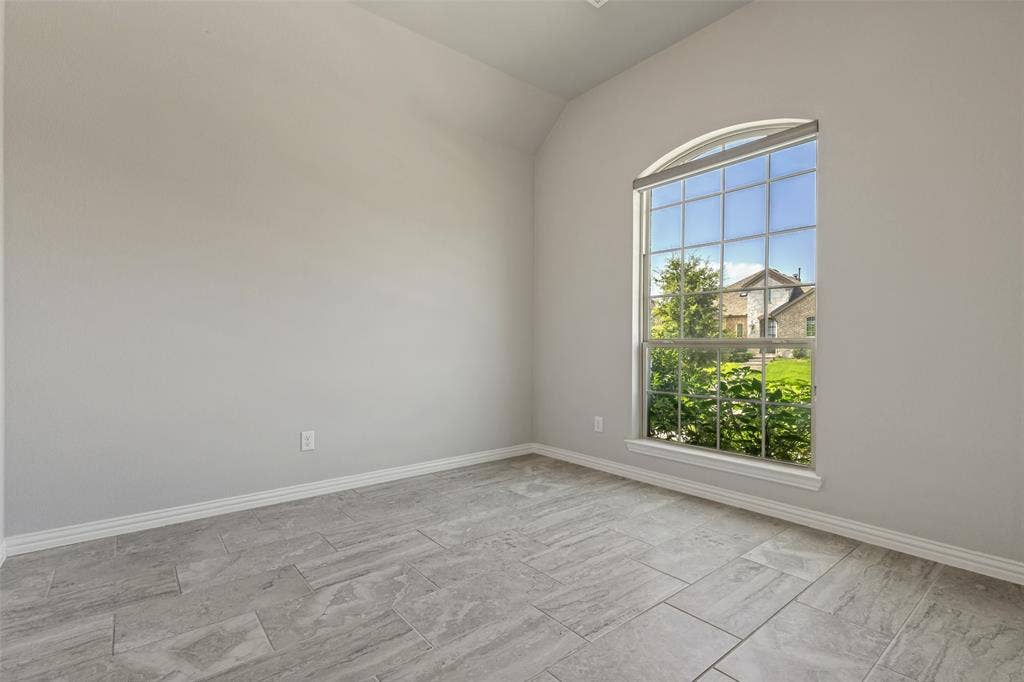 12464 Lost Valley Drive, Frisco, TX 75035 Arched window offering natural light, complemented by light gray paint and a vaulted ceiling