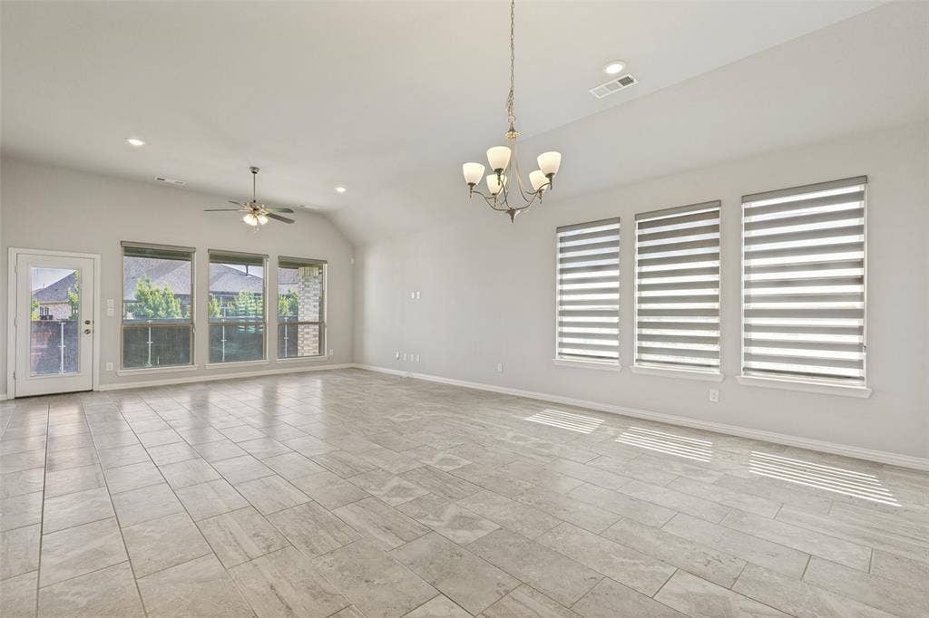 12464 Lost Valley Drive, Frisco, TX 75035 Spacious living area featuring large format tile flooring, vaulted ceilings, and recessed lighting