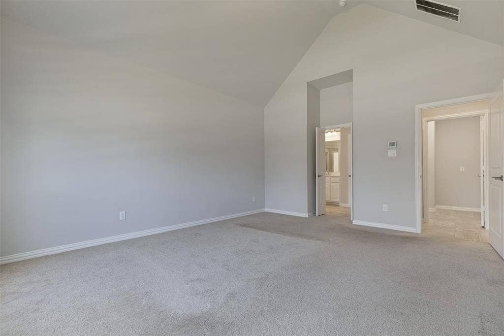 12464 Lost Valley Drive, Frisco, TX 75035 Spacious interior room featuring a vaulted ceiling, light gray wall paint, and carpeting