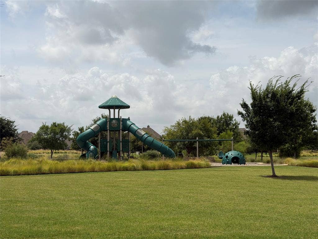 12464 Lost Valley Drive, Frisco, TX 75035 Expansive green space featuring a playground with a tower, multiple slides, and a swingset