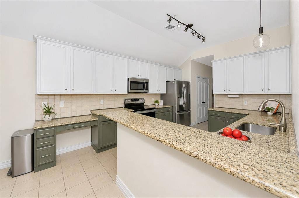 5304 Fox Run Drive, Watauga, TX 76137 The built-in desk area offers a convenient workspace with granite countertops, ample cabinetry, and dedicated task space, making it ideal for a home office, homework station, or household organization center.