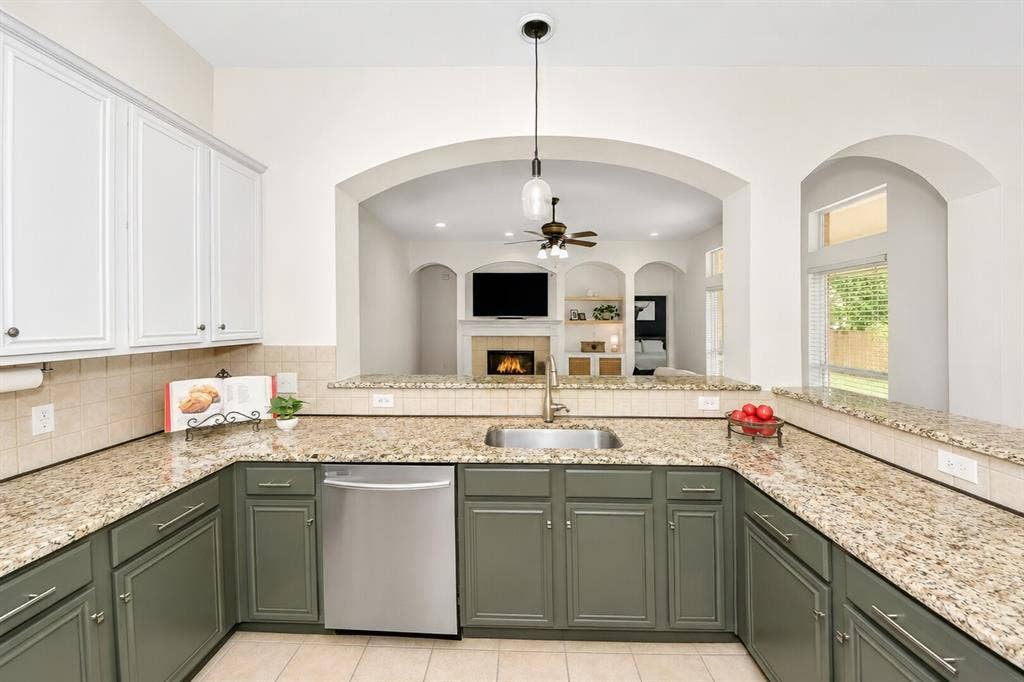 5304 Fox Run Drive, Watauga, TX 76137 The chef-inspired kitchen features expansive granite countertops, abundant two toned cabinetry, and an open-concept design that overlooks the spacious living area—perfect for everyday living and entertaining.