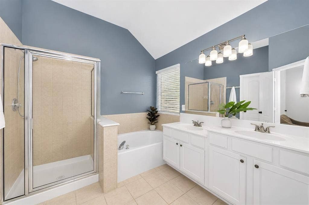 5304 Fox Run Drive, Watauga, TX 76137 Relax and unwind in the spacious primary bath featuring dual vanities, a soaking garden tub, and a separate glass-enclosed shower.