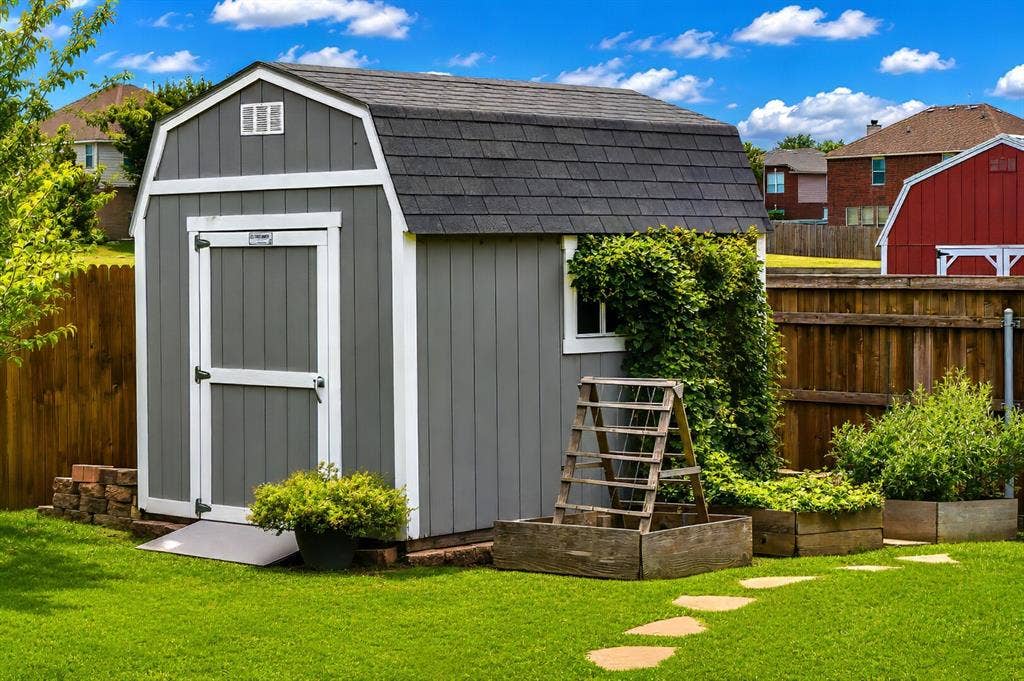 5304 Fox Run Drive, Watauga, TX 76137 A charming storage shed and raised garden beds add both functionality and character to the backyard, providing the perfect space for gardening, hobbies, and convenient outdoor storage.