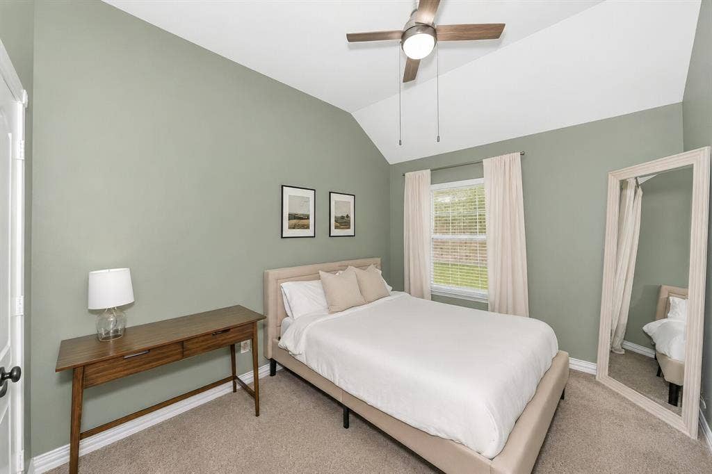 5304 Fox Run Drive, Watauga, TX 76137 The spacious guest bedroom offers vaulted ceilings, soft neutral tones, plush carpeting, a ceiling fan.