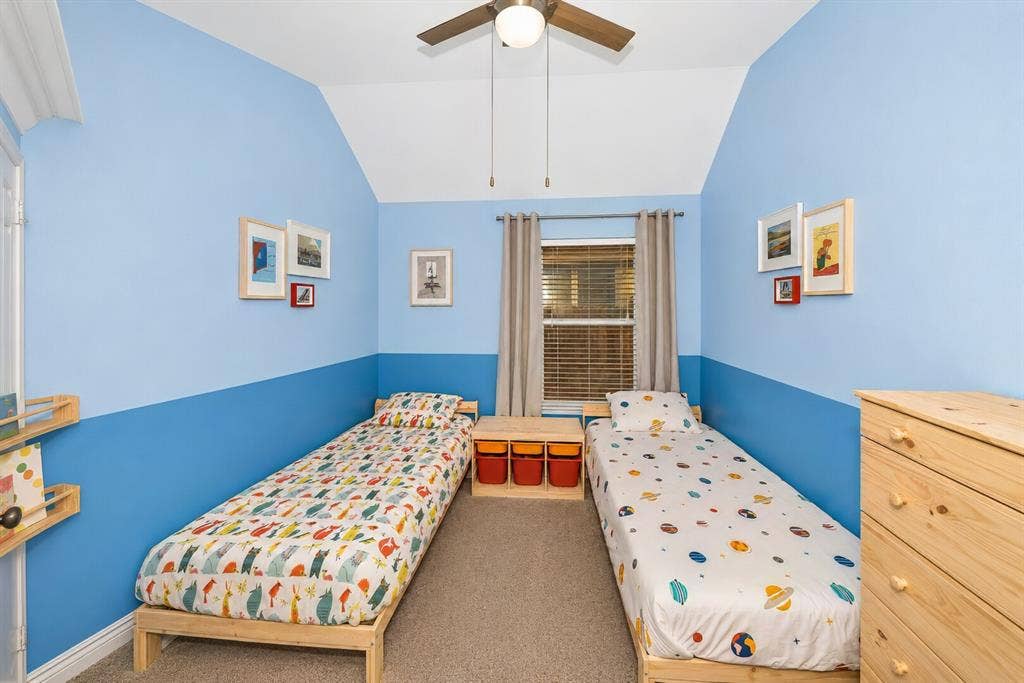 5304 Fox Run Drive, Watauga, TX 76137 This cheerful secondary bedroom features vaulted ceilings, plush carpeting, a ceiling fan, and a large window that fills the space with natural light, making it an ideal room for children, guests, or a creative flex space.