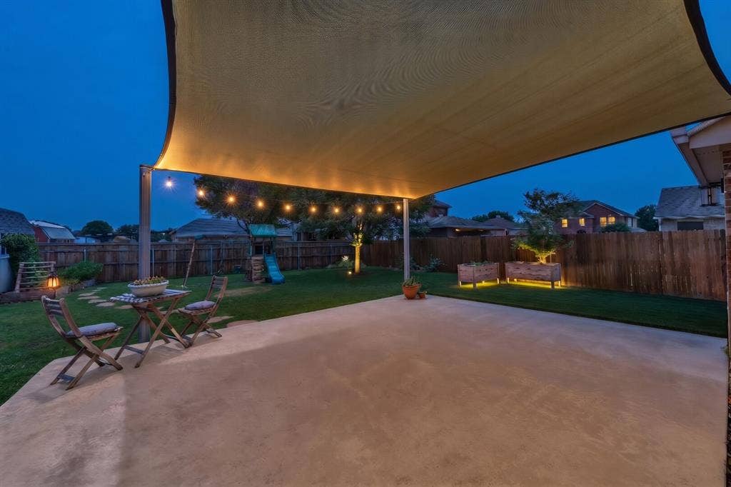 5304 Fox Run Drive, Watauga, TX 76137 As evening falls, imagine adding illumination to shade sail, café lights, landscape lighting to your spacious patio to create the perfect setting for outdoor dining, entertaining, or simply relaxing while overlooking the beautifully landscaped backyard. (photographer provided lighting as inspiration only)
