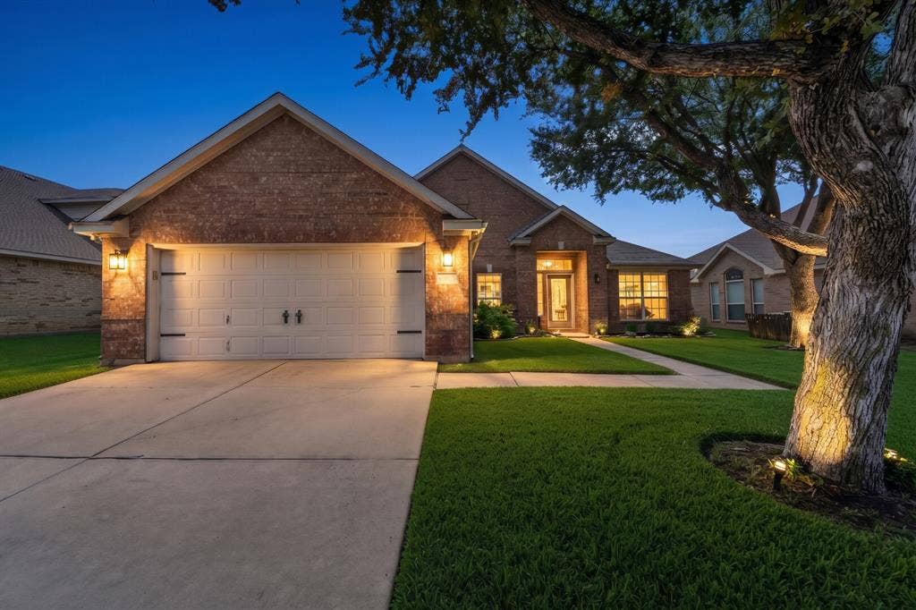 5304 Fox Run Drive, Watauga, TX 76137 As the sun sets, this beautifully maintained home truly shines with elegant landscape lighting, a welcoming front entry, and exceptional curb appeal, creating a warm first impression you'll be proud to call home. The tree lighting was enhanced by the photographer for inspiration.