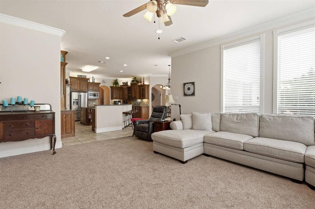 5030 Monroe Court, Midlothian, TX 76065 Open-concept living space featuring carpet flooring and crown molding