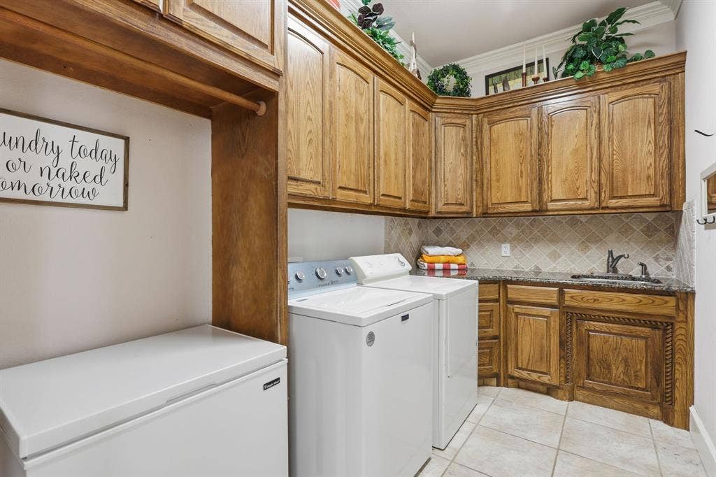 5030 Monroe Court, Midlothian, TX 76065 Dedicated utility room featuring wood cabinetry, a built-in sink, stone countertop, tiled backsplash, and tile flooring