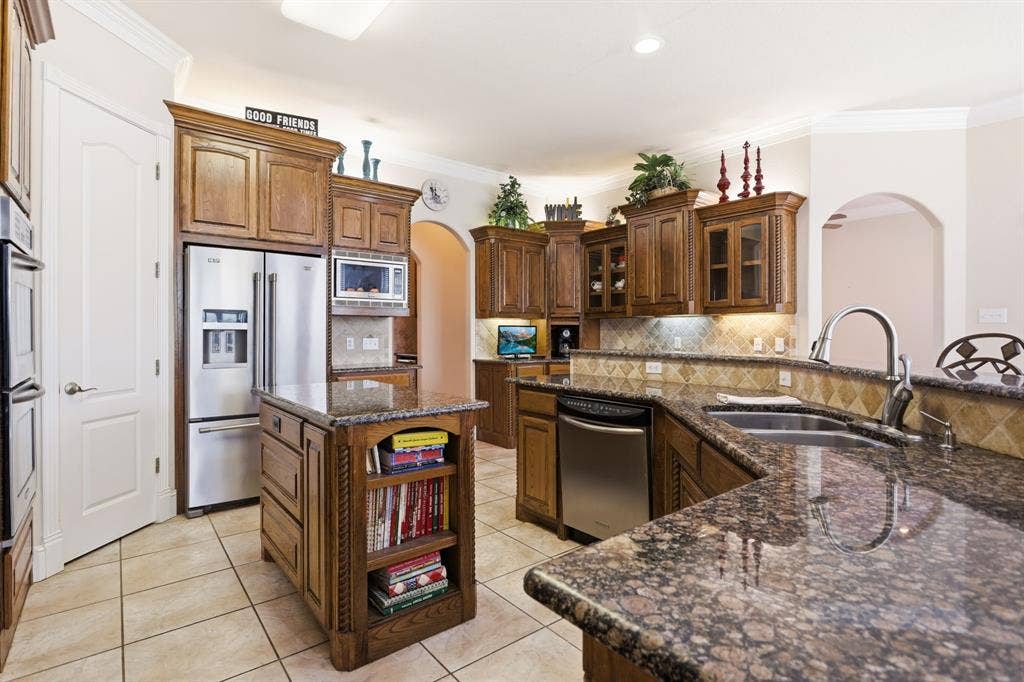5030 Monroe Court, Midlothian, TX 76065 Kitchen featuring granite countertops, wood cabinetry, stainless steel appliances, a tile backsplash, and a center island