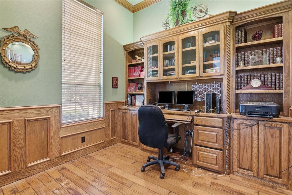 5030 Monroe Court, Midlothian, TX 76065 Dedicated office space featuring extensive built-in custom cabinetry, integrated desk area, and wood-finish flooring